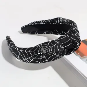 Halloween black knotted headband with shiny silver spider web pattern detail close-up