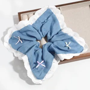 Detailed close-up of blue denim hair scrunchie with white lace trim and cute colorful mini bows.