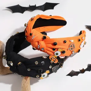Detailed shot of Halloween rhinestone knotted headbands with cute pumpkin and ghost charms.
