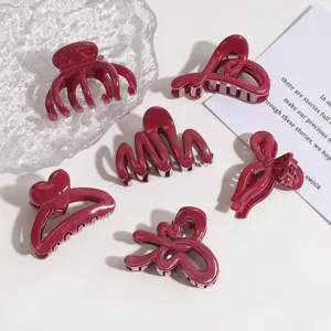 Nahaufnahme glänzender roter Haarklammern in niedlichen Formen wie Schleifen und Herzen.