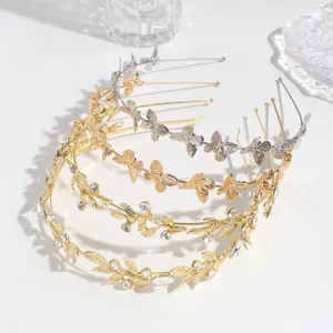 Detalles en primer plano de diademas de metal con mariposas y estrás doradas y plateadas.