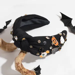 Close-up detail of the black wide knotted rhinestone headband featuring festive Halloween charms.