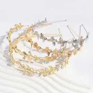 Primer plano detallado de diademas metálicas con hojas y mariposas de pedrería brillante.