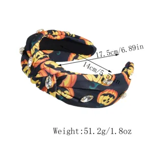 Detail view of Halloween pumpkin printed knotted headband with sparkling rhinestones.