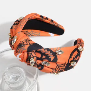 Close-up of Halloween knotted headband with rhinestones, pumpkin and spiderweb patterns.