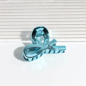 Nahaufnahme einer metallisch blauen Haarklammer mit glänzender Oberfläche und feiner Textur.