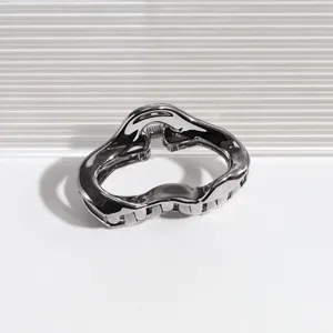 Nahaufnahme der grauen Metall Haarklammer mit glatten, geschwungenen Rändern und Zähnen.