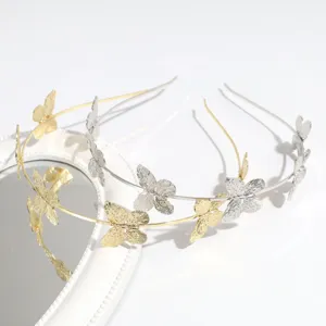 Detalle en primer plano de la diadema de mariposa de metal en oro y plata con textura fina.