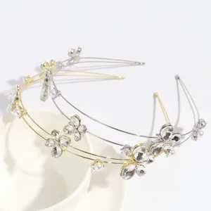 Primer plano detallado de aros para el cabello de metal con flores de diamantes y perlas.