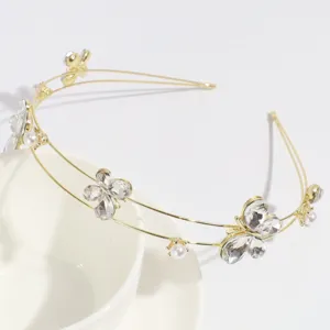 Detalle de diadema dorada con mariposas de pedrería, accesorio elegante de doble capa.