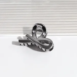 Detailansicht der kleinen metallischen Haarklammer mit glänzender geometrischer Form.
