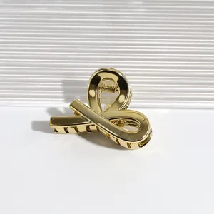 Nahaufnahme einer stilvollen goldenen Haarspange aus Metall mit einzigartigem Schlaufendesign.