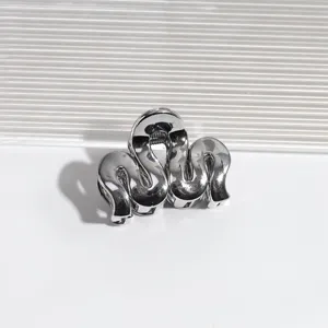 Detailaufnahme einer silbernen metallischen Wellen-Haarklammer, elegantes Haaraccessoire.