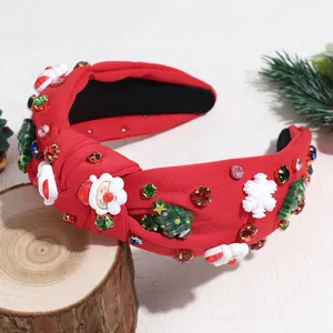 Close-up of red knotted Christmas headband with rhinestone, Santa and tree charms.