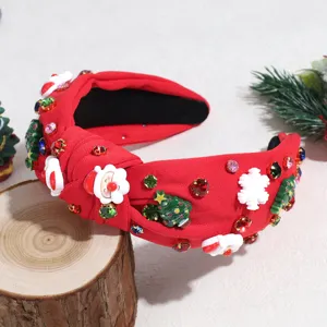 Detail view of red christmas knotted headband with rhinestone, santa and tree ornaments.