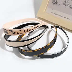 Close-up view of chic fashion leopard print and tortoise shell headband details for styling.