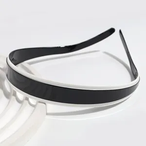 Close-up view of the black and white colorblock headband, glossy finish hair accessory.