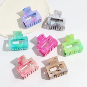 Close-up detail of multi-color marbled small hair claws, showing resin material and chic design.