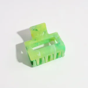 Detailed view of the 4cm marbled small hair claw clip showing its unique green and yellow pattern.