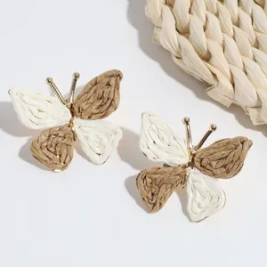Bohemian straw woven butterfly stud earrings, gold metal frame, natural forest style jewelry.