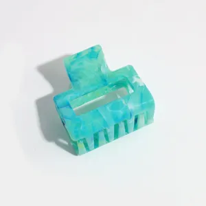 Detailed close-up of the small blue marbled hair claw clip, highlighting its unique texture.
