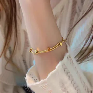 Minimalist double layer gold tone chain bracelet with chic square charms for elegant daily wear.