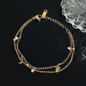 Close-up of the double layer gold chain bracelet with star and moon charms and rhinestones.