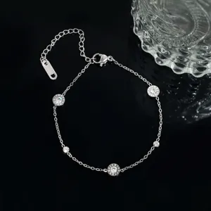Close-up of silver-tone stainless steel station bracelet with Roman numeral rhinestone charms.