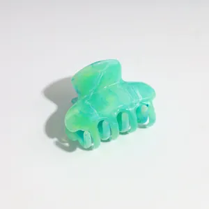 Small marbled hair claw clip detail shot, green and blue resin hair accessory for women.