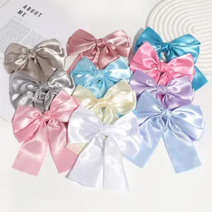 Detailed view of colorful satin ribbon bow hair clips, vintage style elegant hair accessories.