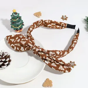 Vue détaillée du serre-tête nœud de Noël en tissu marron avec un motif de fête.