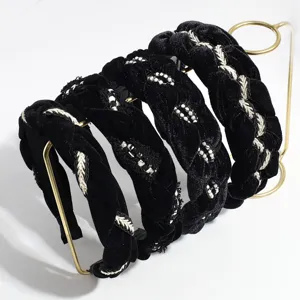 Detail view of black velvet braided hairband with pearl embroidery for elegant autumn winter look.