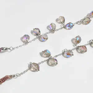 Vue détaillée de perles de cristal facettées scintillantes sur une chaîne de cheveux.