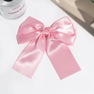 Pink satin bow hair clip with long ribbon tails, elegant sweet hair accessory for women.