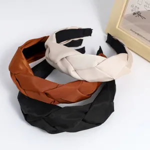 Detail view of stylish braided fabric headbands in three versatile autumn and winter colors.