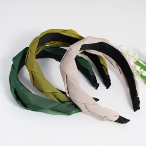 Detailed view of fashionable braided fabric hair hoop, elegant solid color headband for women.