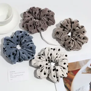 Detailed view of retro autumn winter polka dot velvet scrunchies for chic low ponytails.