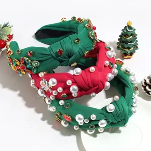 Weihnachtsknoten-Haarreif Detailansicht mit Perlen und Strass auf grünem und rotem Stoff.