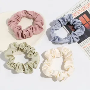 Vue détaillée d'élastique en satin montrant la texture plissée et la durabilité pour coiffures.