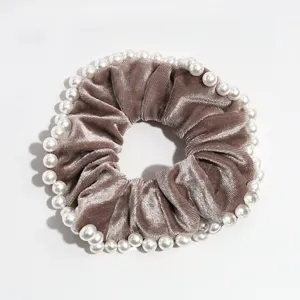 Vista dettagliata del raffinato elastico per capelli in velluto con perle decorative.