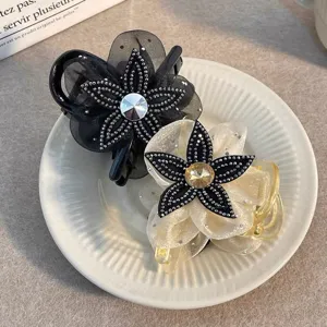 Close-up of elegant mesh flower hair claw featuring sparkling rhinestone details and glossy finish.