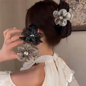 Detailed view of elegant mesh flower hair claw clip with sparkly rhinestones for women.