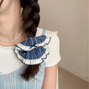 Detailed view of the blue striped ruffled hair scrunchie, sweet lace hair accessory.