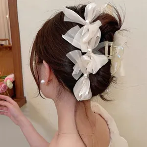 Detail view of elegant mesh bow hair claw with pearl accents for women and girls daily wear.