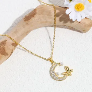 Close-up detail of the elegant gold moon and butterfly rhinestone pendant necklace.