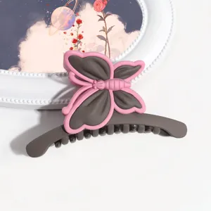 Primo piano di una pinza per capelli a farfalla opaca in grigio scuro e rosa, elegante.