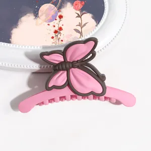 Molletta per capelli a farfalla rosa opaco in dettaglio, accessorio per capelli dolce ed elegante.