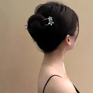 Close-up detail of crystal flower hair stick worn in elegant hair bun, sparkling rhinestone accent.