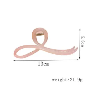 Vista detallada de la elegante pinza para el pelo rosa irregular, mostrando su forma y tamaño.