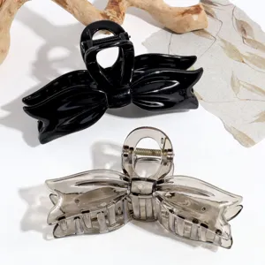 Vista detallada y cercana de pinzas para el cabello con lazo en negro y gris, accesorio.